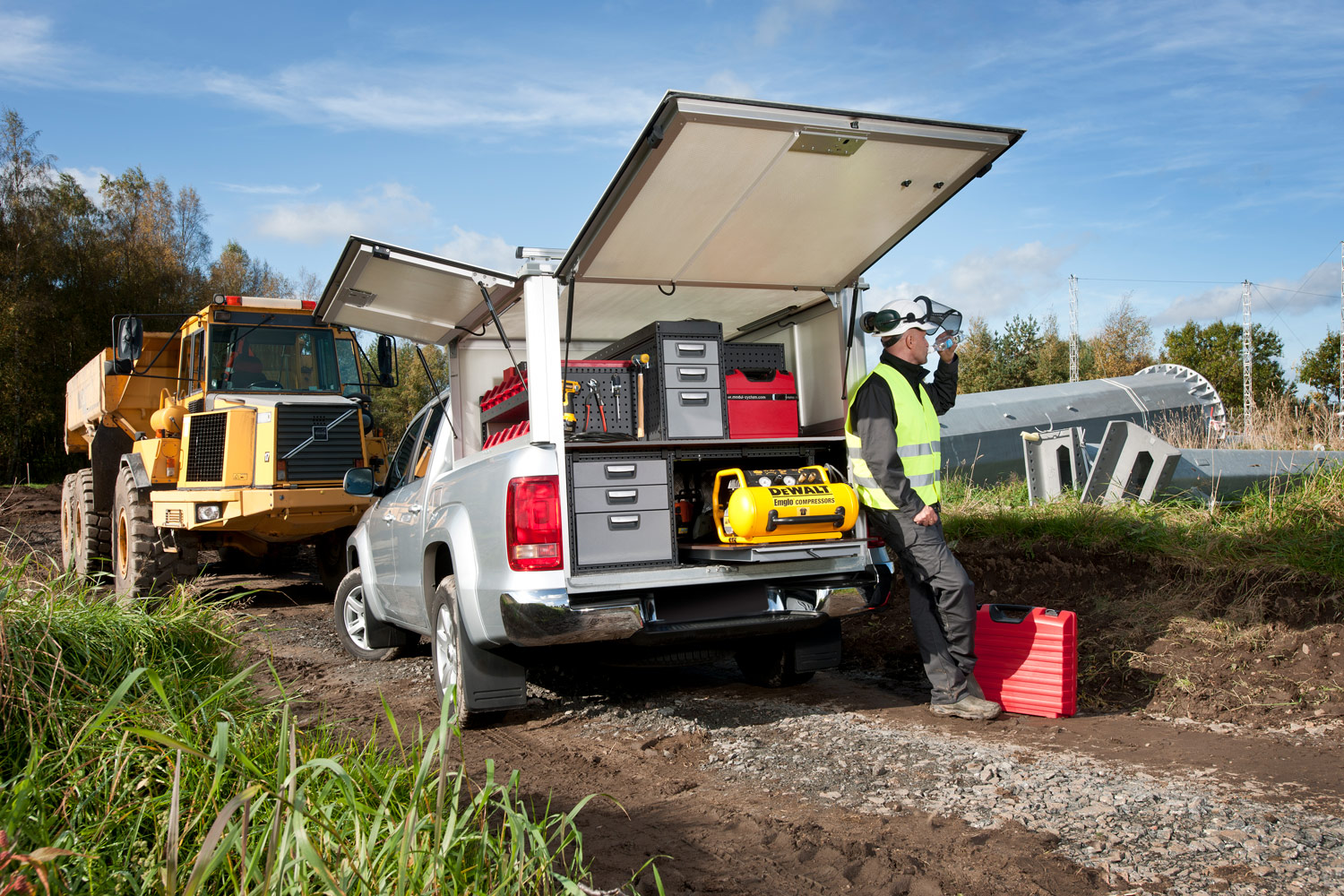 Worker's silver pickup truck with modul-system shelving on the job